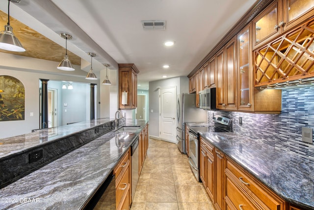 kitchen with dark stone countertops, backsplash, hanging light fixtures, and stainless steel appliances