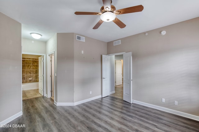 unfurnished bedroom with ceiling fan, connected bathroom, and dark hardwood / wood-style flooring