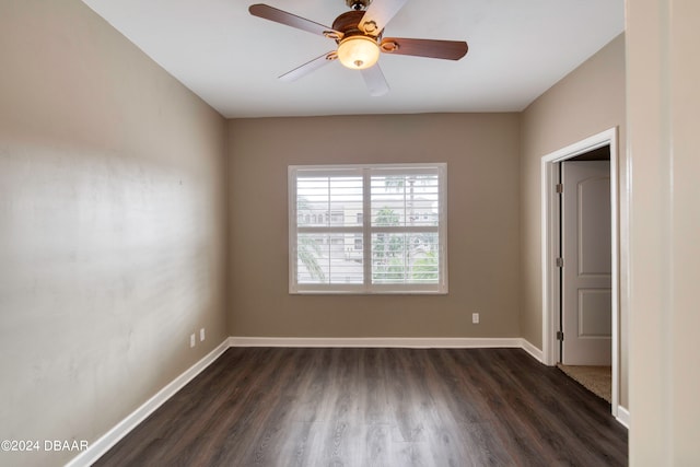 spare room with dark hardwood / wood-style flooring and ceiling fan