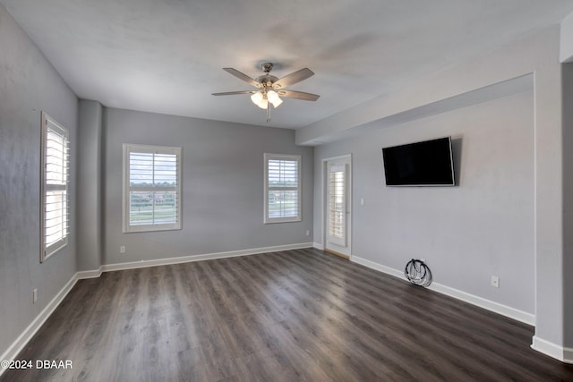 empty room with dark wood-type flooring and ceiling fan