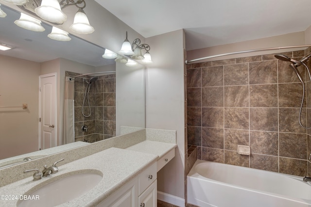 bathroom with a chandelier, vanity, and tiled shower / bath