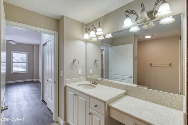 bathroom with vanity, wood-type flooring, and ceiling fan with notable chandelier