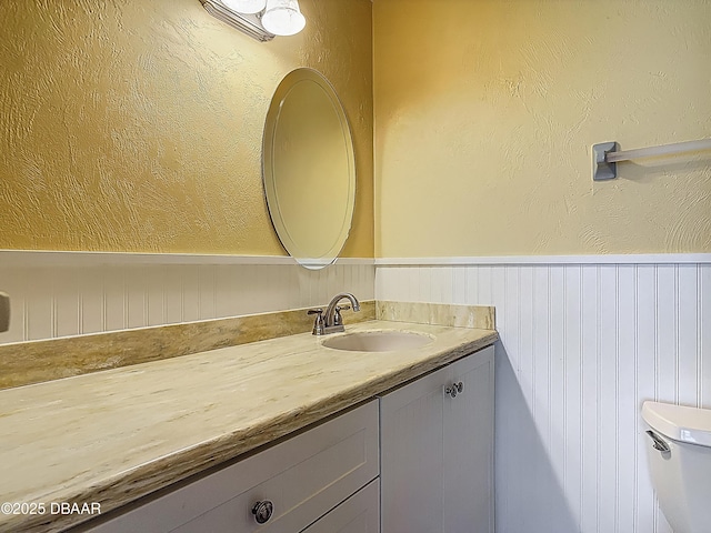 1926 Ocean Shore Blvd Unit 3120, Ormond Beach, FL 32176 - bathroom featuring toilet, vanity, and a wainscoted wall