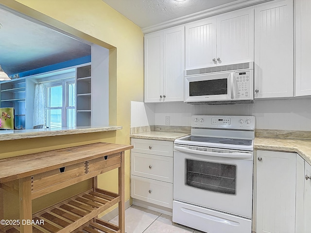 1926 Ocean Shore Blvd Unit 3120, Ormond Beach, FL 32176 - kitchen with white cabinets, light countertops, light tile patterned flooring, and white appliances
