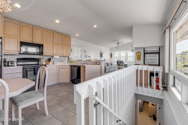 kitchen with plenty of natural light, black appliances, tasteful backsplash, and lofted ceiling