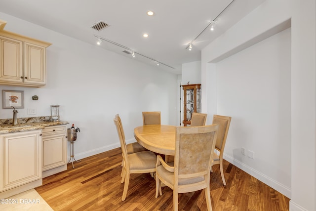 dining area featuring light hardwood / wood-style floors and rail lighting