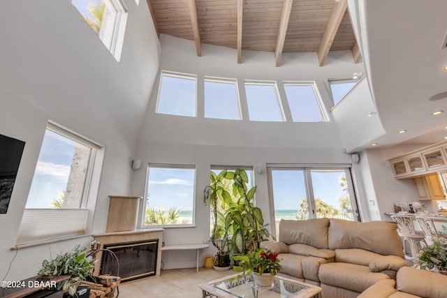 tiled living room featuring a high ceiling and plenty of natural light