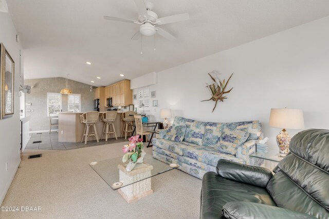 living room with vaulted ceiling, light colored carpet, and ceiling fan