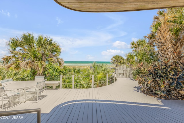 wooden terrace with a view of the beach and a water view