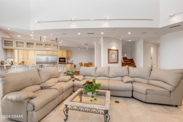 tiled living room with a towering ceiling