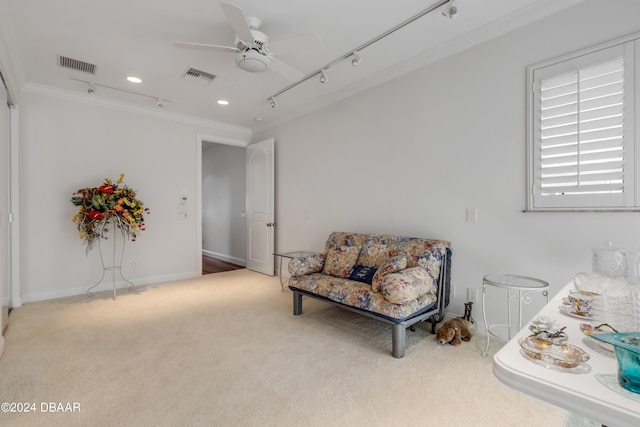 living area featuring ornamental molding, light carpet, and ceiling fan