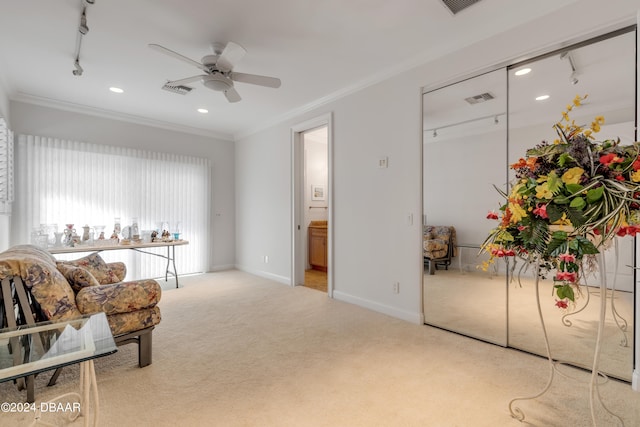 sitting room featuring ceiling fan, rail lighting, light carpet, and crown molding