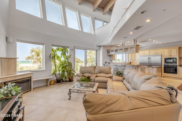 tiled living room with high vaulted ceiling, a wealth of natural light, and beam ceiling