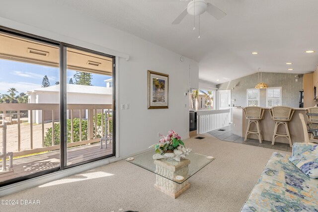 carpeted living room with a healthy amount of sunlight, ceiling fan, and vaulted ceiling