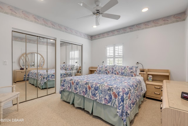 carpeted bedroom with multiple closets and ceiling fan