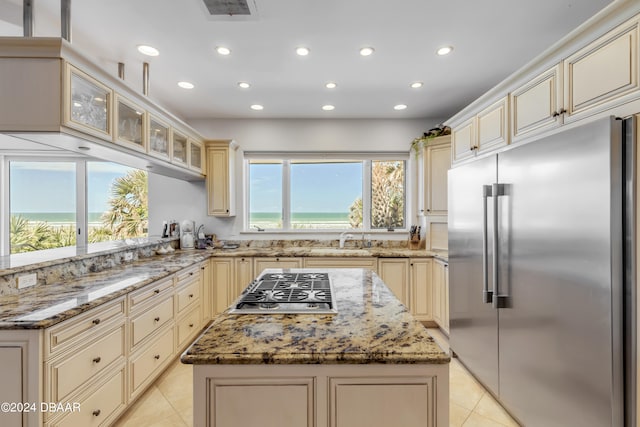 kitchen featuring stainless steel appliances, light stone countertops, and a kitchen island