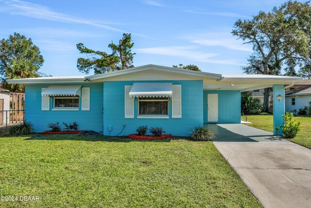 ranch-style house with a front yard and a carport