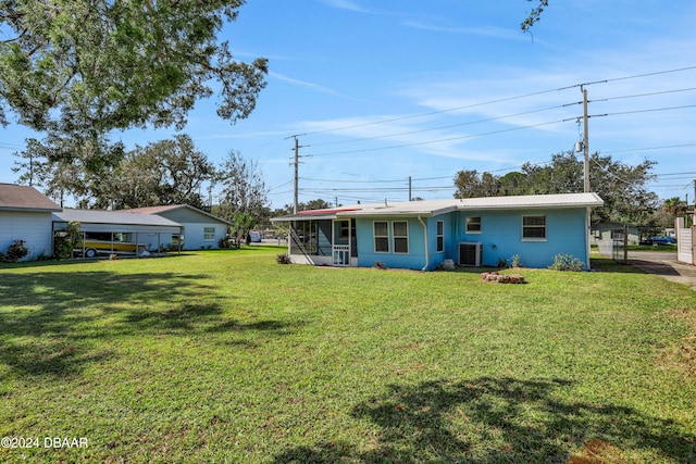 exterior space with central AC, a yard, and a carport