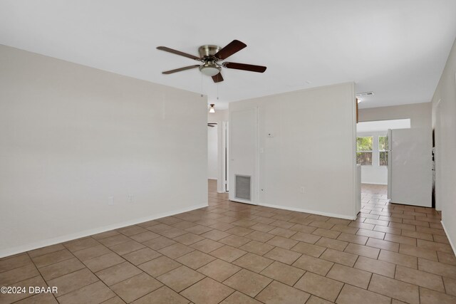 tiled empty room featuring ceiling fan