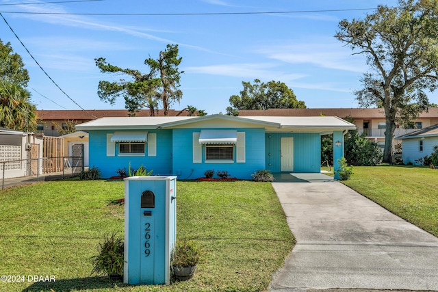 ranch-style home with a front yard and a carport