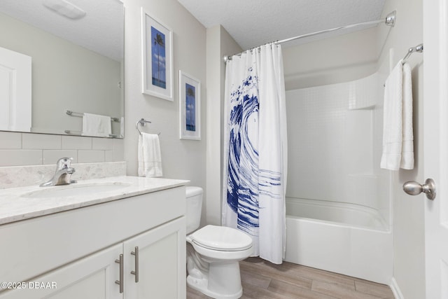 full bathroom featuring a textured ceiling, toilet, wood finished floors, vanity, and shower / bath combo