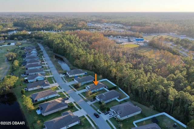 drone / aerial view featuring a residential view and a forest view