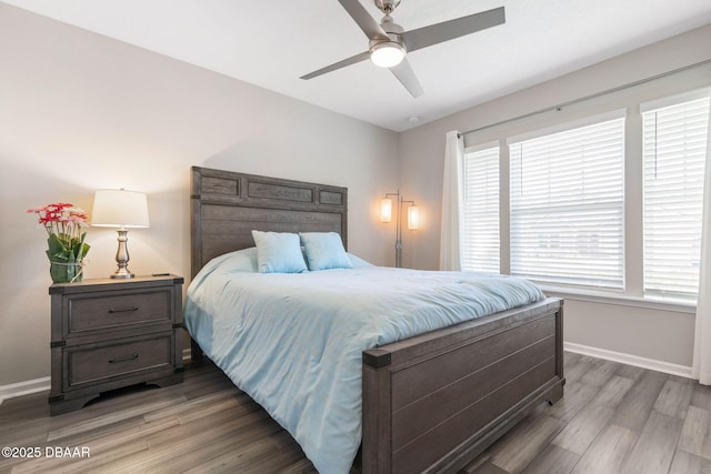 bedroom featuring ceiling fan, baseboards, and wood finished floors