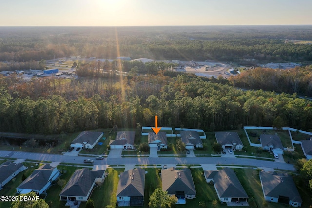 drone / aerial view featuring a residential view and a view of trees