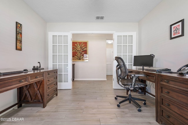 office area featuring french doors, visible vents, light wood-style floors, a textured ceiling, and baseboards