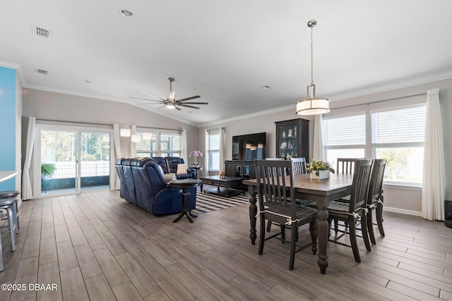 dining space with lofted ceiling, a wealth of natural light, visible vents, and wood finished floors