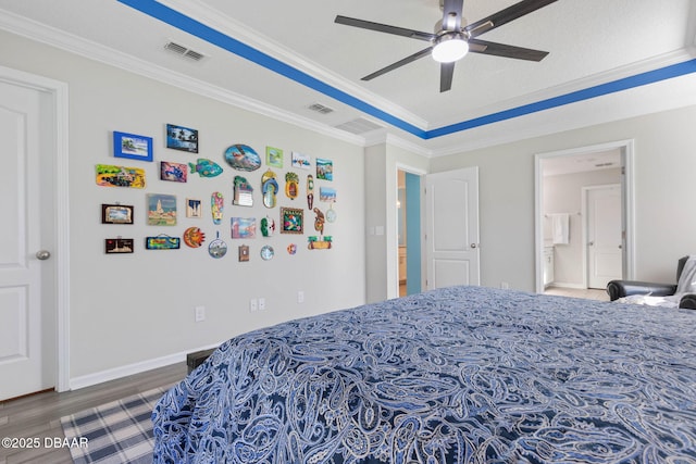 bedroom featuring visible vents, wood finished floors, and ornamental molding