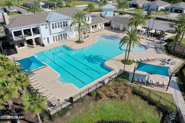 pool with a patio and fence