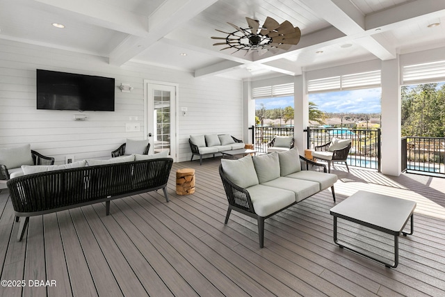 wooden deck featuring outdoor lounge area, a ceiling fan, and an outdoor pool