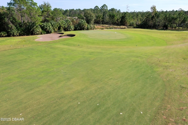 surrounding community with golf course view and a lawn