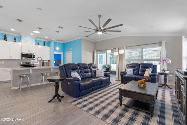 living area with ornamental molding, lofted ceiling, light wood-type flooring, and visible vents