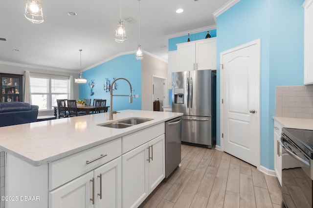 kitchen featuring light wood-style floors, ornamental molding, stainless steel appliances, and a sink