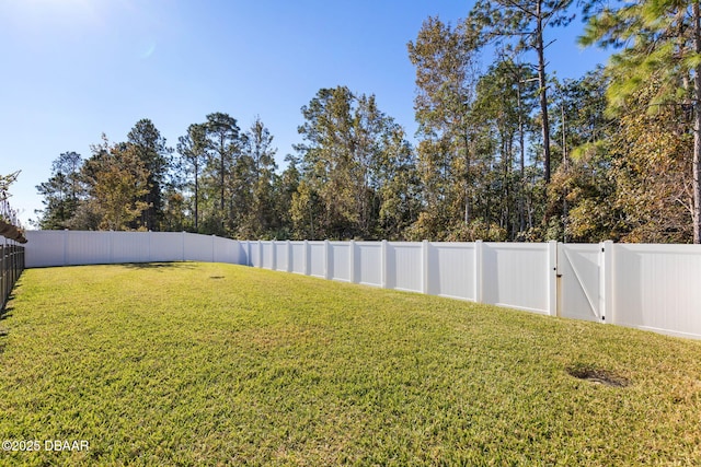 view of yard with a fenced backyard and a gate