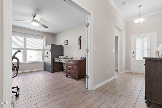 interior space featuring baseboards, a textured ceiling, a ceiling fan, and light wood-style floors