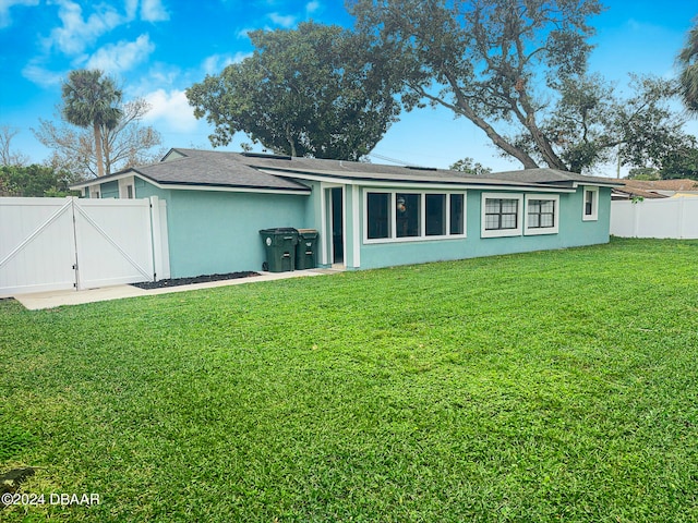 back of property featuring a lawn