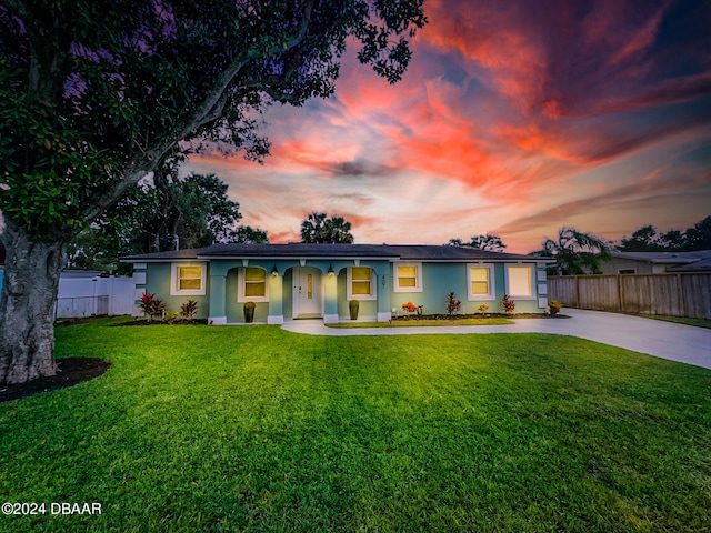 back house at dusk with a lawn