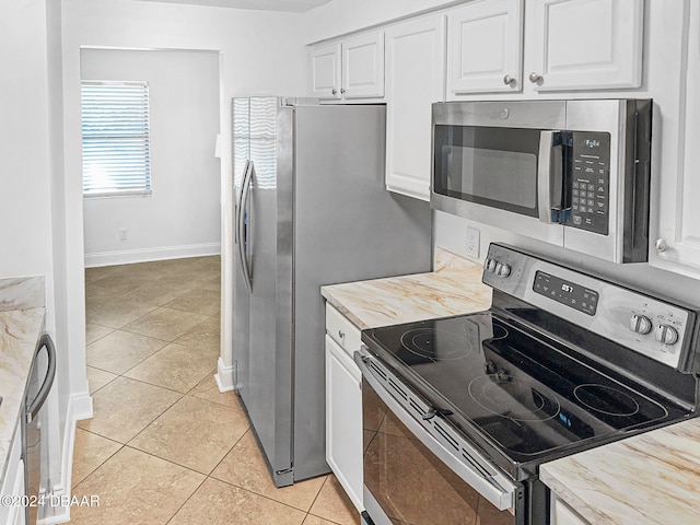 kitchen featuring stainless steel appliances, wood counters, white cabinetry, and light tile patterned floors