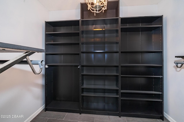 walk in closet with an inviting chandelier