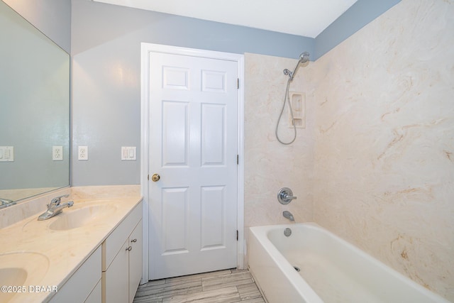 bathroom featuring tiled shower / bath combo and vanity