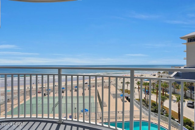 balcony with a water view and a view of the beach