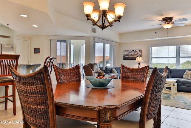 tiled dining room featuring plenty of natural light and ceiling fan with notable chandelier