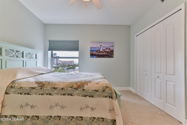 carpeted bedroom with ceiling fan and a closet