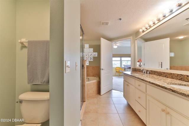 bathroom featuring vanity, tile patterned floors, a relaxing tiled tub, ceiling fan, and a textured ceiling