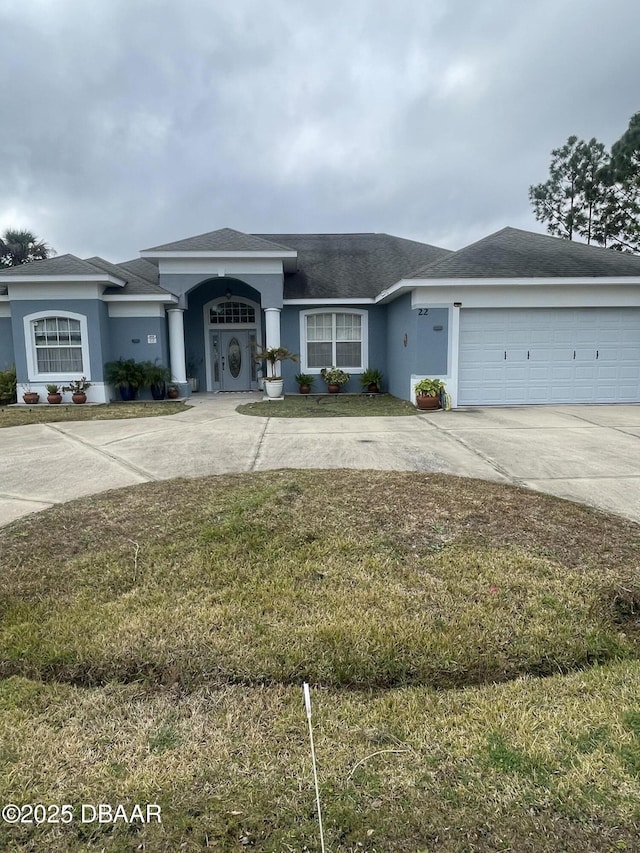 single story home featuring a garage and a front lawn