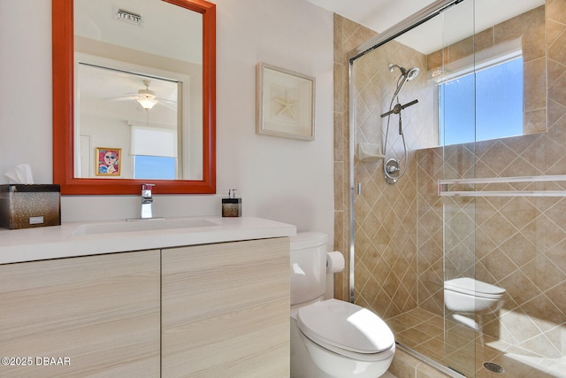 bathroom with visible vents, a shower stall, toilet, and vanity