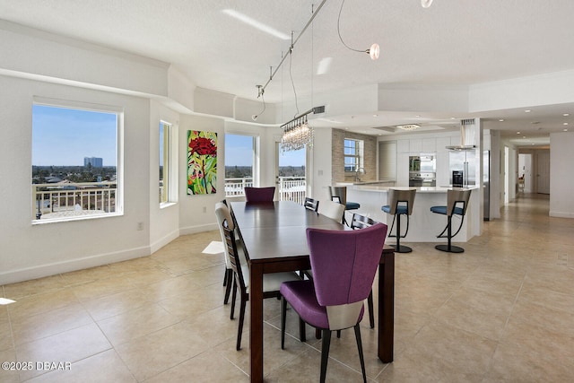 dining space with light tile patterned floors, a healthy amount of sunlight, and baseboards